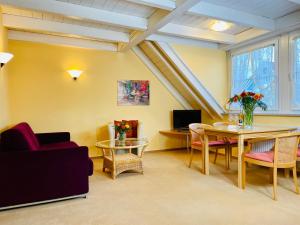 a living room with a couch and a table and chairs at Hotel Im Winkel Appartements und Zimmer in Langenargen