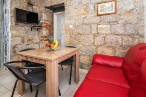 a living room with a wooden table and a red couch at Tamaria in Split
