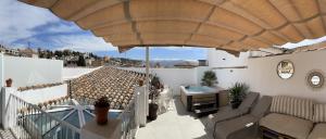 a patio with an umbrella and a table on a balcony at CALM SUITES Molino Corteza del Carmen in Granada