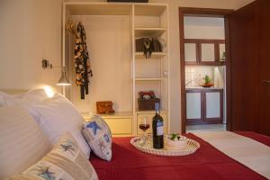 a room with a bed with a bottle of wine at Aristea Studios in Sarti