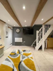 uma sala de estar com uma televisão e um tapete em Garden Room @ Bosanath Mill em Falmouth