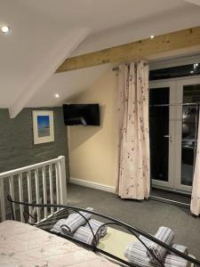 ein Schlafzimmer mit einem Bett und einem TV in einem Zimmer in der Unterkunft Garden Room @ Bosanath Mill in Falmouth