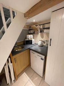a small kitchen with a sink and a microwave at Garden Room @ Bosanath Mill in Falmouth