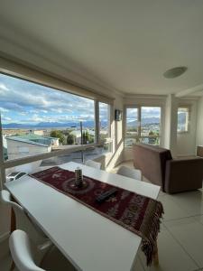 sala de estar con mesa y ventana grande en Depto en Los Canelos en Ushuaia