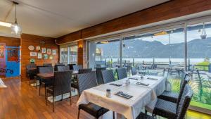 un restaurant avec des tables et des chaises et une grande fenêtre dans l'établissement Hôtel du Poète, à Aix-les-Bains