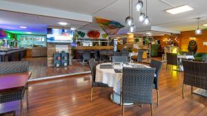 une salle à manger avec une table et des chaises dans un restaurant dans l'établissement Hôtel du Poète, à Aix-les-Bains