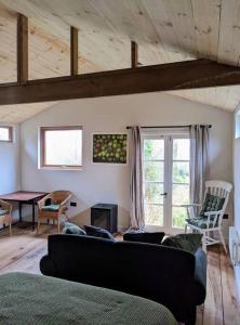 a living room with a couch and a table at A Somerset Countryside Lodge in Holcombe