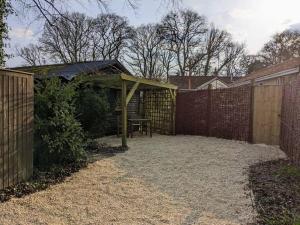 a backyard with a picnic table and a fence at A Somerset Countryside Lodge in Holcombe