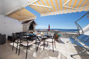a patio with a table and chairs and a fireplace at Villa Fina in Tučepi