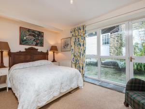 a bedroom with a bed and a large window at Lower Mill in Dartmouth