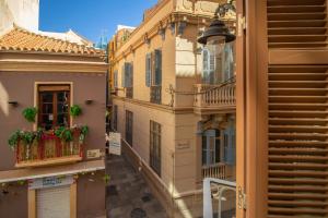 an alley between two buildings with flower boxes and a balcony at Flat 2 bedrooms in the City Center in Málaga
