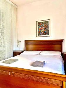 Un dormitorio con una cama de madera con una foto en la pared en Appartamento a Tempio Pausania, en Tempio Pausania