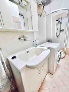 騰匹歐保沙尼亞的住宿－Appartamento a Tempio Pausania，白色的浴室设有水槽和卫生间。