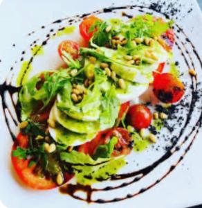 a plate of food with broccoli and other vegetables at Hotel Rural Palacete de Mañara in Montejaque