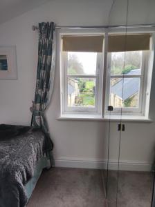 sypialnia z łóżkiem i oknem w obiekcie Pleasant streams Barn w mieście St Austell