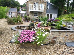 einen Garten mit Blumen vor einem Haus in der Unterkunft Pleasant streams Barn in St Austell