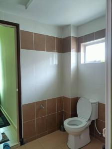 La salle de bains est pourvue de toilettes et d'une fenêtre. dans l'établissement Inapan Masdar - Mumtaz, à Changlun
