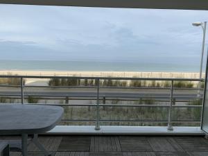 a balcony with a table and a view of the beach at Appartement T2 neuf avec parking à Fort-Mahon-Plage - FR-1-482-77 in Fort-Mahon-Plage