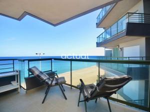 two chairs on a balcony with a view of the beach at Fanals 5B in Platja d'Aro