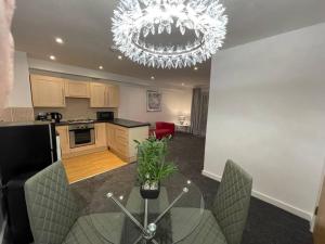 a kitchen with a glass table and a chandelier at Moda Wigan 2 - Stylish 2 Bed in Central Wigan in Wigan