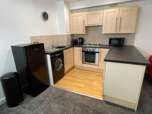 uma cozinha com um frigorífico e uma máquina de lavar louça em Moda Wigan 2 - Stylish 2 Bed in Central Wigan em Wigan