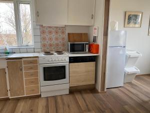 a kitchen with a white stove and a refrigerator at Álftártunga Farm Guesthouse in Borgarnes