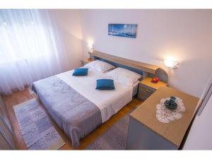 a bedroom with a large bed with blue pillows at Apartment Miranda in Slatine