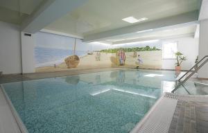 ein Pool in einem Haus mit einem Gemälde an der Wand in der Unterkunft Ostseeresidenz Gorki- Park - 03 mit Wellness und Schwimmbad in Bansin