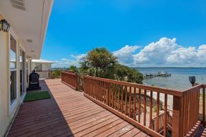 una terraza de madera con vistas al agua en Le Starboard House en Pensacola Beach
