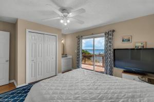 1 dormitorio con 1 cama y TV de pantalla plana en Le Starboard House en Pensacola Beach