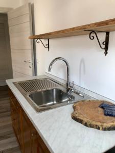 cocina con fregadero y tabla de cortar de madera en CasaTati, en Molina di Ledro