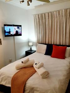 a bedroom with a bed with towels on it at La Grace Executive Guesthouse in Amsterdamhoek