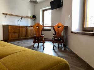 two chairs in a room with a kitchen and a bed at CasaTati in Molina di Ledro