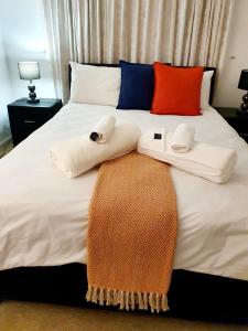 a bed with two towels sitting on top of it at La Grace Executive Guesthouse in Amsterdamhoek