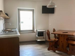 a kitchen with a table and a sink and a window at CasaTati in Molina di Ledro