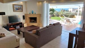 - un salon avec un canapé et une cheminée dans l'établissement Holiday villa SUNJOY close to the beach, à Cap Sounion