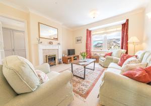 a living room with two couches and a fireplace at 7 Greta Grove House in Keswick