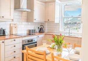 a kitchen with a table and chairs and a window at 7 Greta Grove House in Keswick