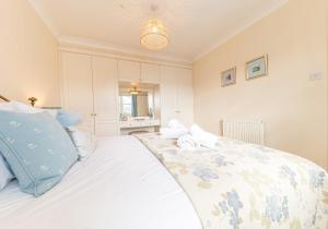 een slaapkamer met een groot wit bed en een blauw kussen bij 7 Greta Grove House in Keswick