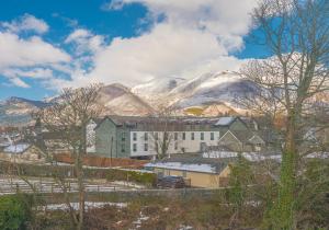 a town with snow covered mountains in the background at 7 Greta Grove House in Keswick