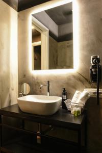 ein Badezimmer mit einem weißen Waschbecken und einem Spiegel in der Unterkunft Il Corso Comfort Rooms in Rom