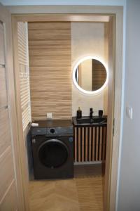 y baño con espejo y lavadora. en Apartament Kadzielnia, en Kielce
