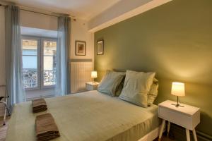 une chambre avec un lit avec deux lampes et une fenêtre dans l'établissement Cote Tendance, à Sarlat-la-Canéda