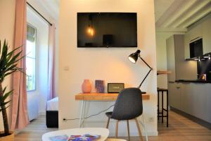 Le Central Rhône 2 - vue grandiose - في ليون: غرفة بها مكتب مع كرسي وتلفزيون