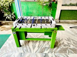 a ping pong table sitting on a green bench at Paris Guest House in Bharatpur