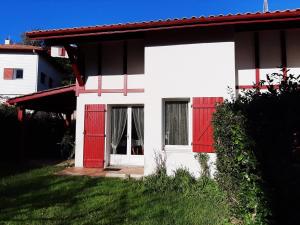 een wit en rood huis met rode deuren bij Maison Urrugne, 3 pièces, 4 personnes - FR-1-239-596 in Urrugne