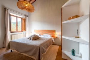 1 dormitorio con cama y ventana grande en Gea - In Parulia Country House, en Arezzo