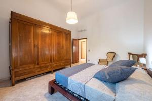 a bedroom with a large bed and a large wooden cabinet at La Fortezza in Florence