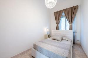 a white bedroom with a bed and a window at La Fortezza in Florence +22 photos