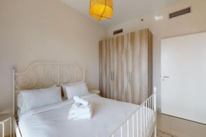 a bedroom with a white bed with a white headboard at Key View - Golf Vita in Dubai Marina